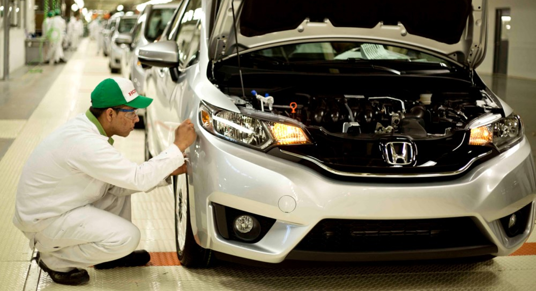 Technicien Honda travaillant sur une voiture à l'usine.